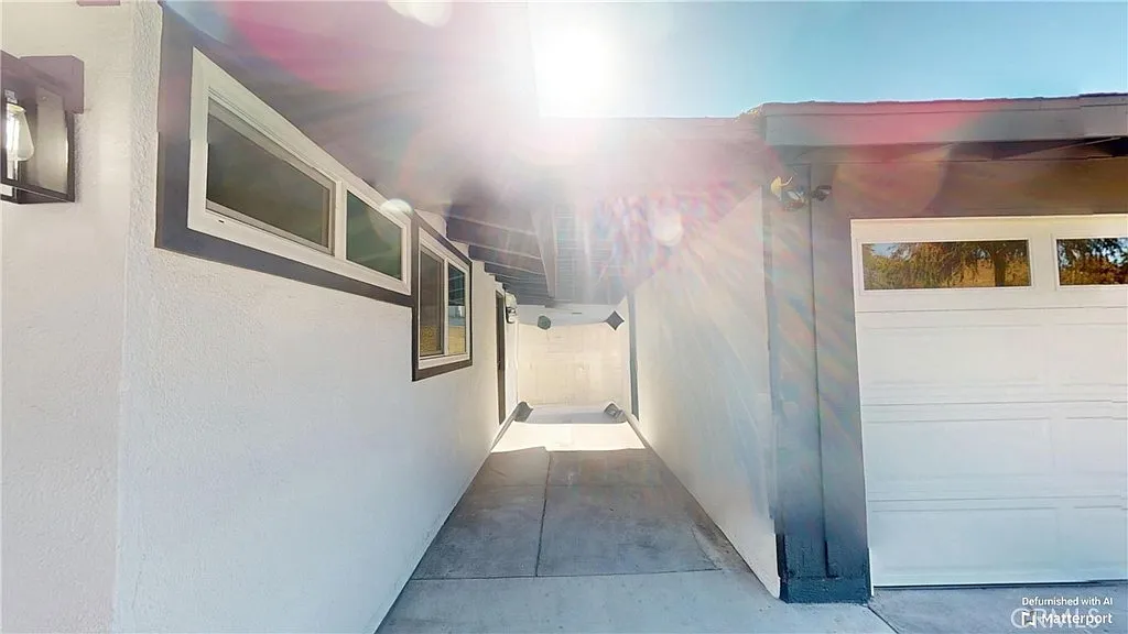 Pathway leading to modern home with white walls and garage door.