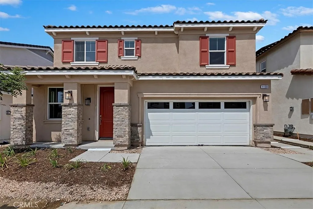 Two-story house real estate with beige walls, red shutters, garage, and front yard.