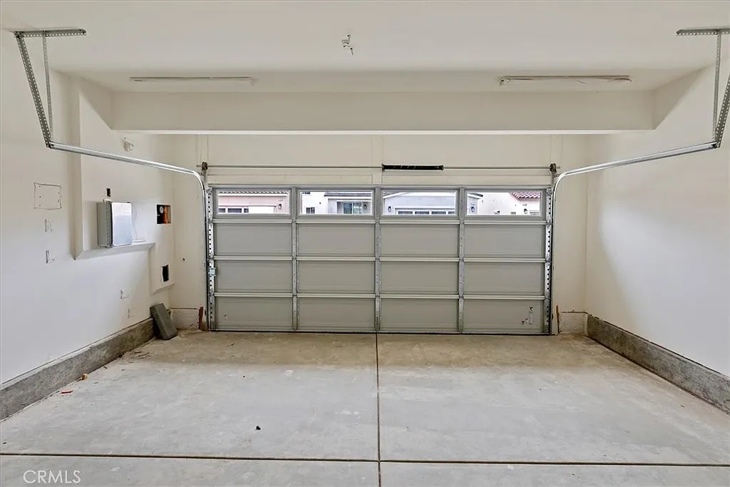 Empty garage with closed door and concrete floor.