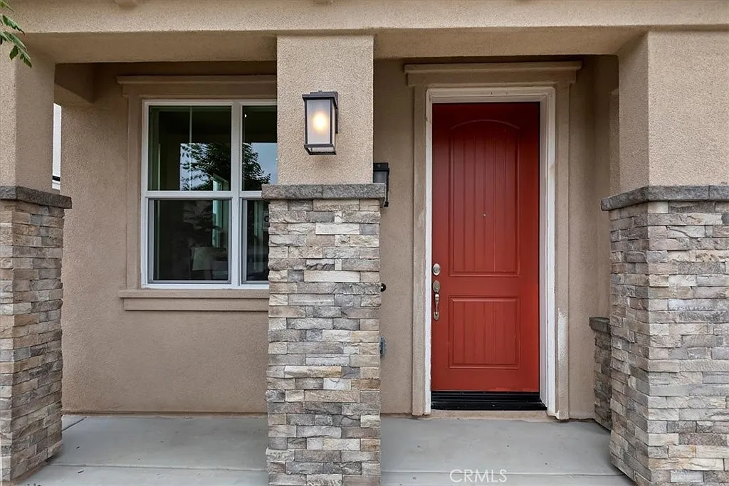 Front entrance of a house with red door and stone
