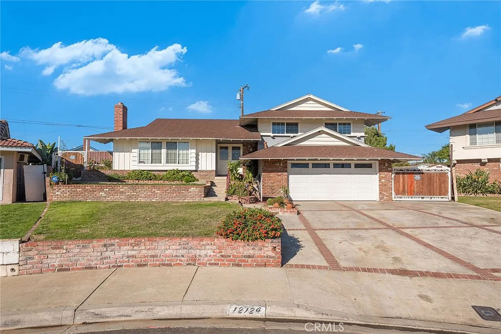 A two-story house with a brown roof, front porch, and landscaped yard on a residential street.