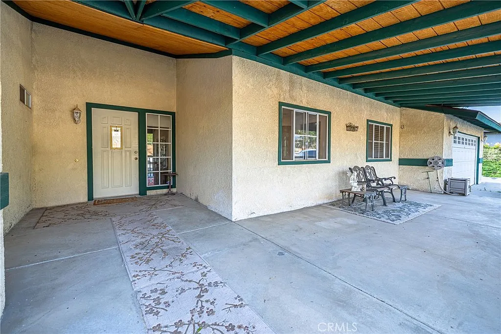 Covered porch of a house with front door, and seating