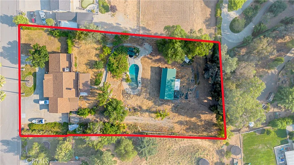 Aerial view of property California real estate with two houses, pool, and trees.