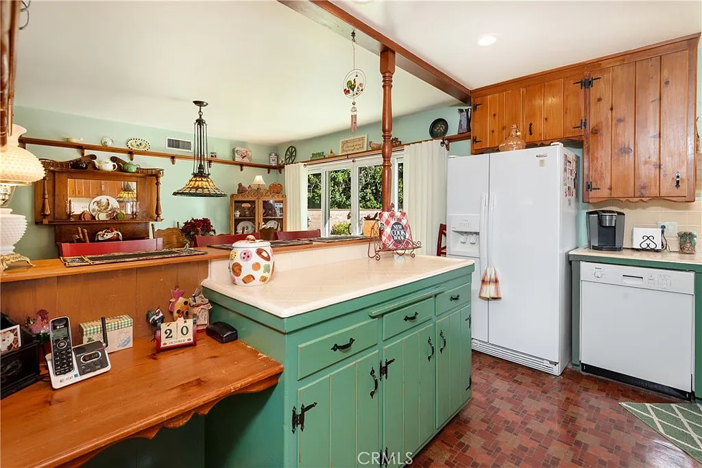 Kitchen with green cabinets, white appliances, wooden accents, and bar area with decorations
