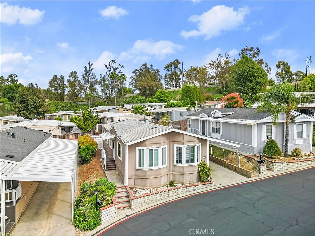Aerial view of mobile homes California real estate with streets, yards, and trees.