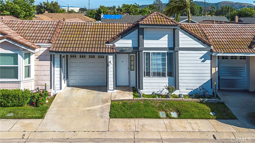 Single-story house with tiled roof, garage, and small front garden, real estate.