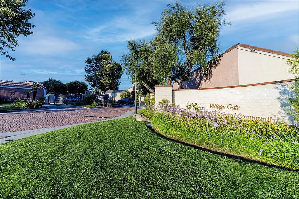 Village Gate community entrance with landscaped area and stone sign.
