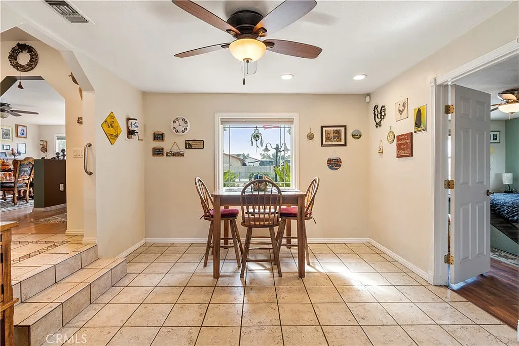 Dining area with round table, chairs, wall art, and window view.