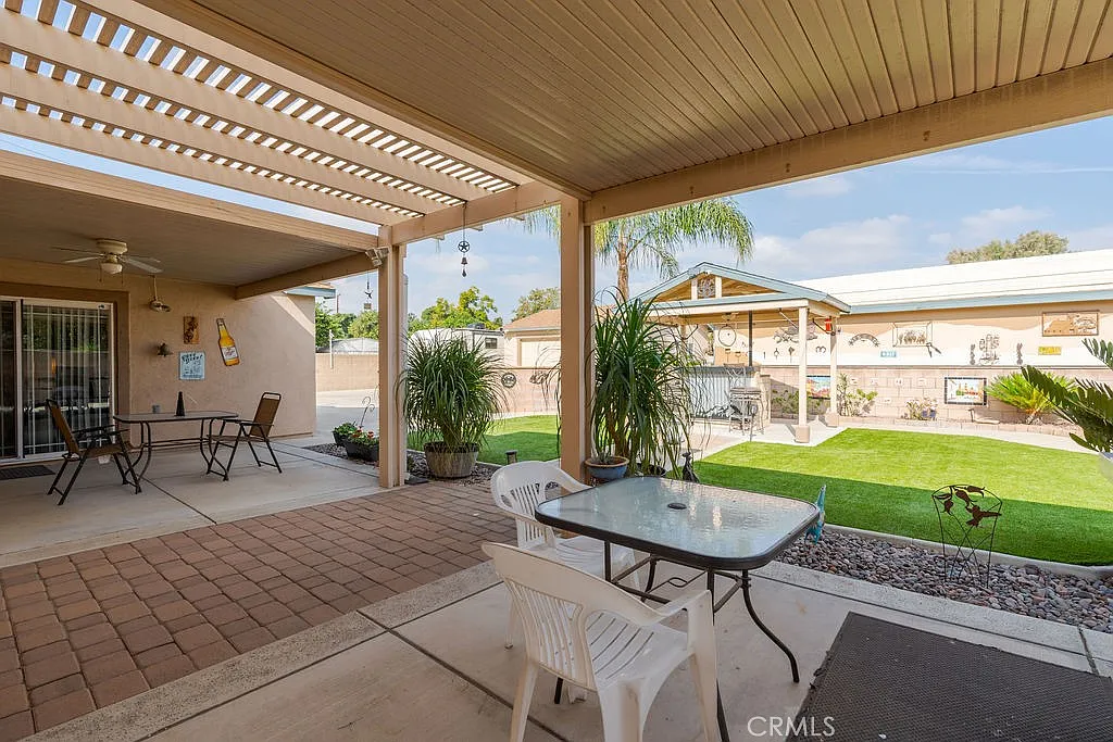 Shaded patio with table and chairs overlooking lawn and garden
