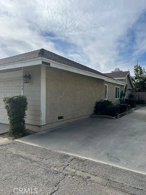 Residential building real estate with light exterior and driveway.