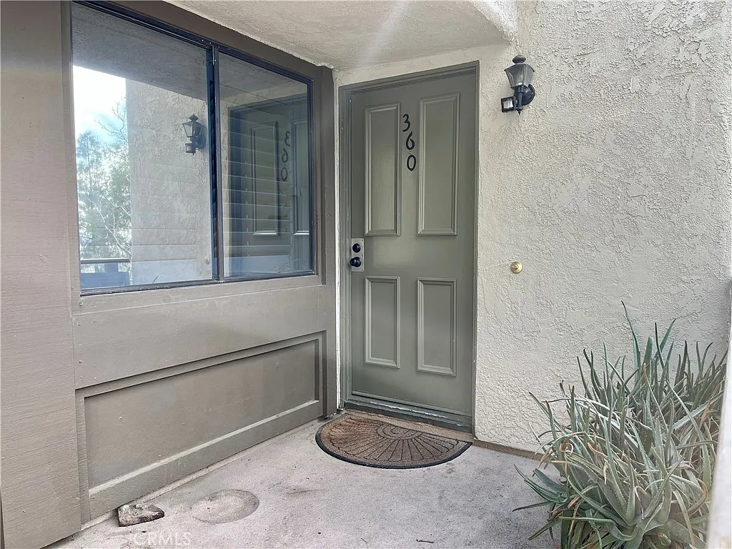 Front door with number 360 and small entry area with mat.