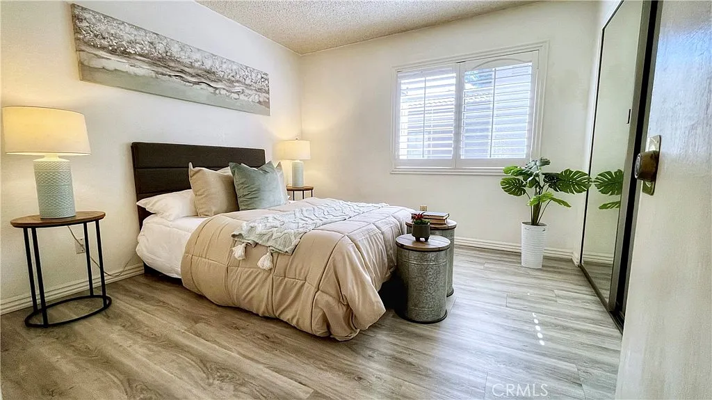 bedroom with bed, soft bedding, bedside lamps, wall decoration, plant