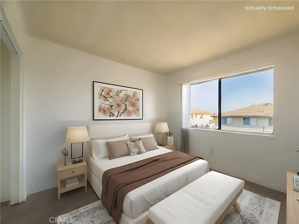 Modern bedroom with bed, decorative pillows, light brown throw, bedside lamps, and window view.