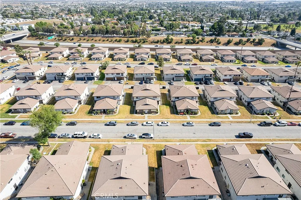 Aerial view of suburban neighborhood with brown roof houses and well-kept lawns.
