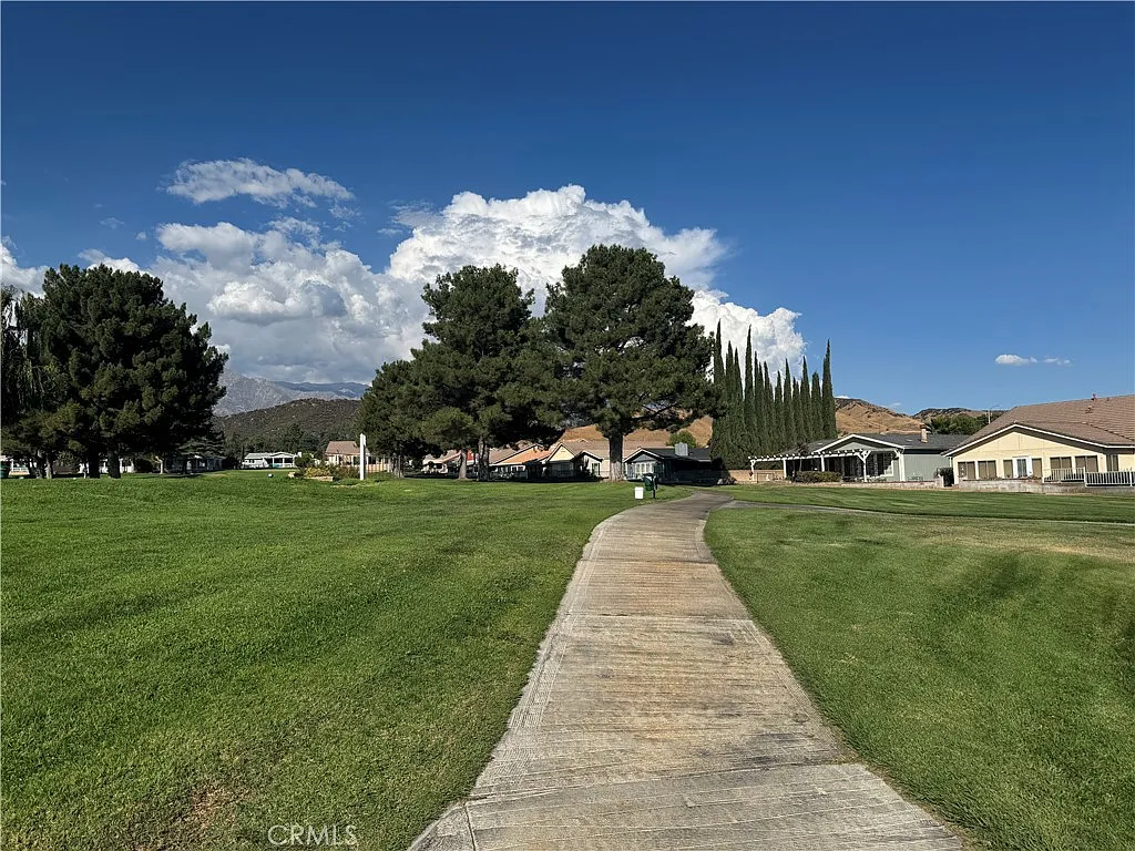 Pathway with grass leading to houses, trees, California real estate.