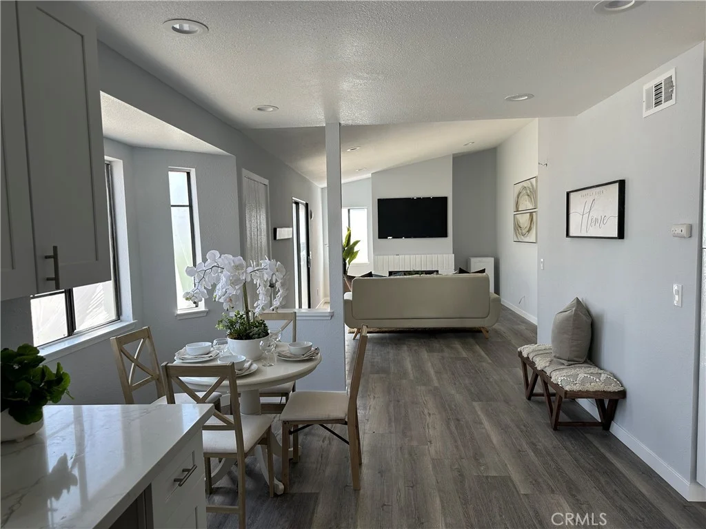 living and dining area with table for four, couch, large windows, and neutral minimalist decor
