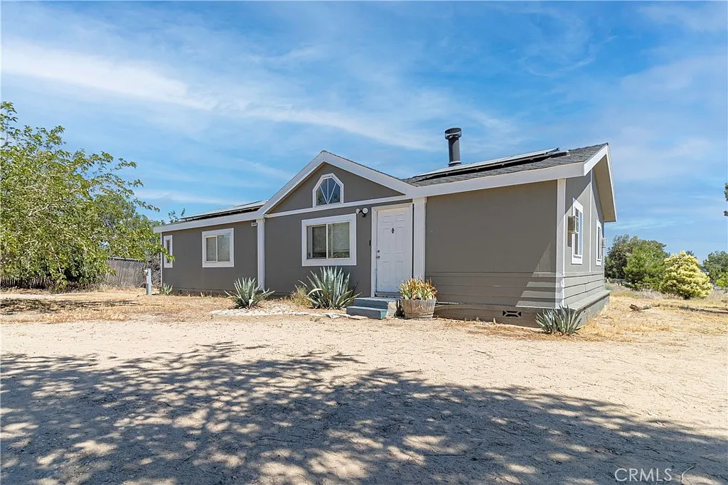 Single-story gray house real estate with white trim and dry landscaping.