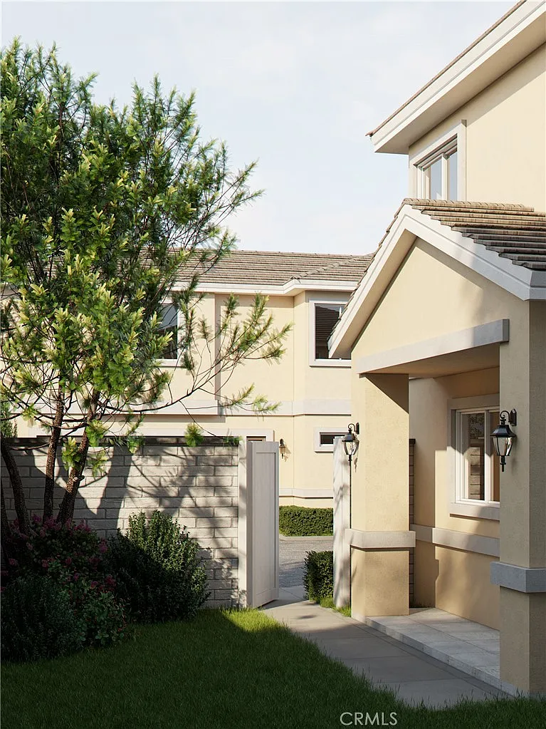 House entrance California real estate with pathway, open gate, and green plants.