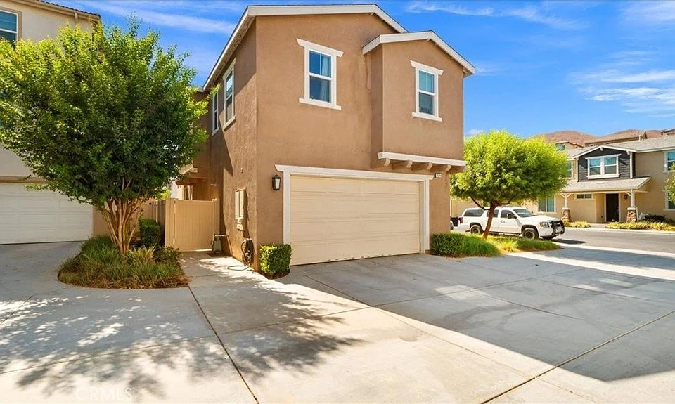 Two-story house California real estate with garage and landscaped yard.