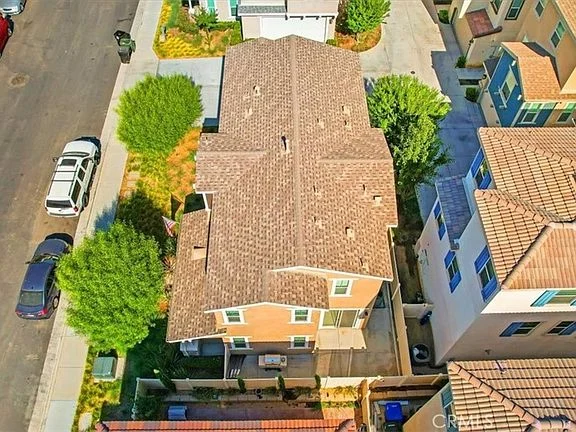 Aerial view of two-story residential buildings with brown roofs and surrounding greenery