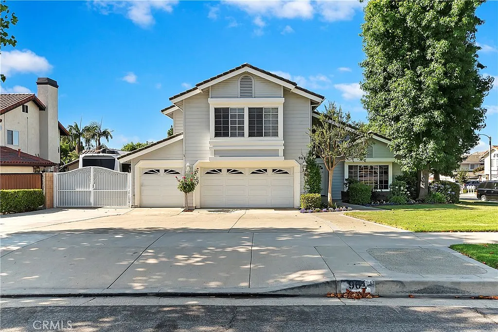 Two-story California real estate house with gray exterior, manicured lawn, and large driveway