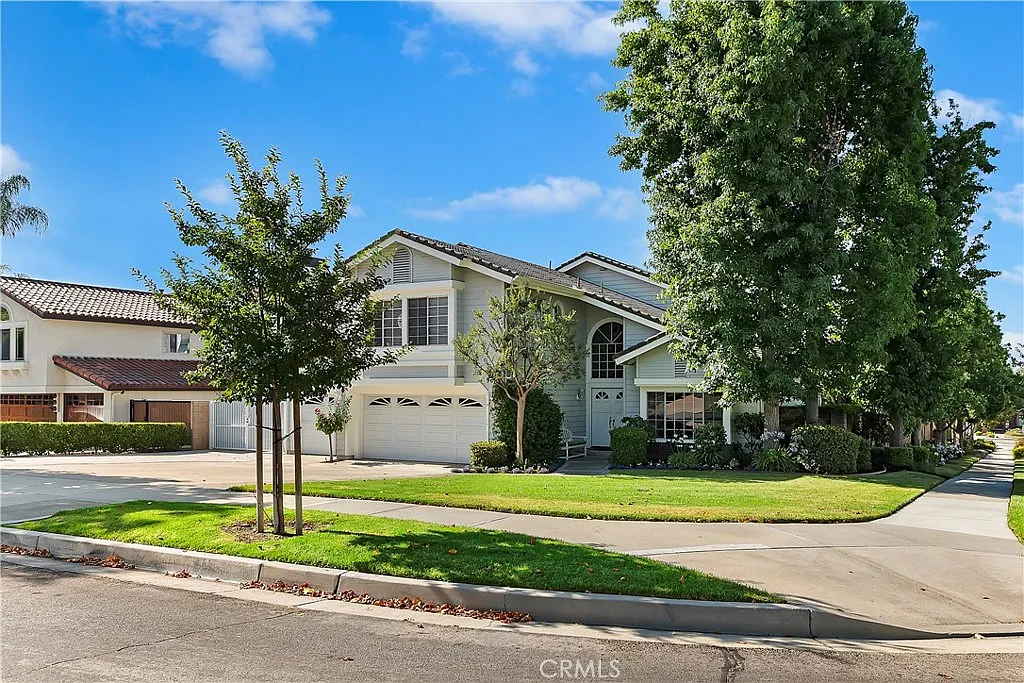 Two-story California real estate house with manicured lawn, trees
