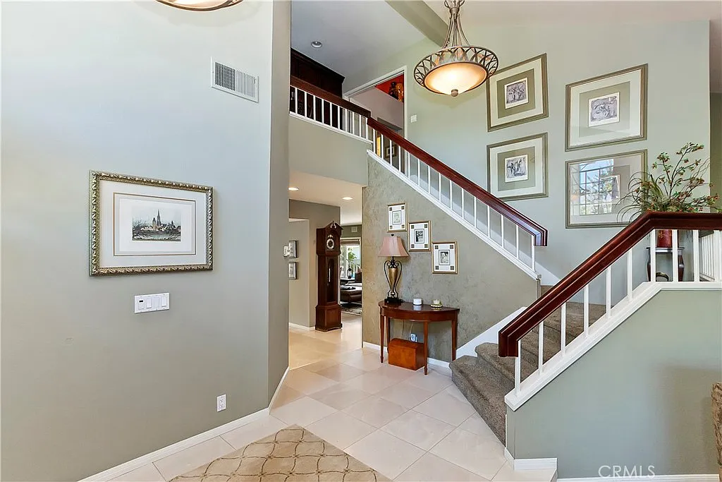 Entryway with staircase, wall art, and small table with lamp
