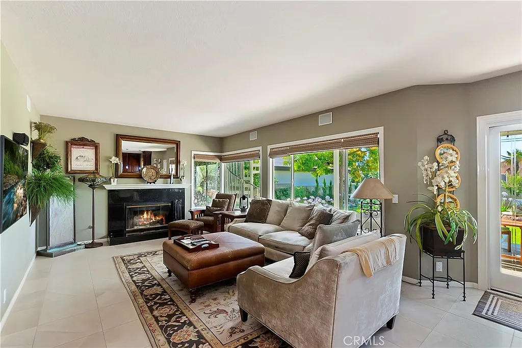 Bright living room with fireplace, comfortable seating, and decorative plants