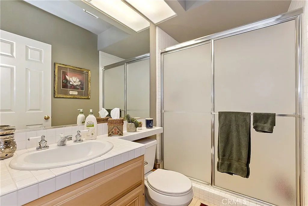 Bathroom with shower, vanity sink, and decorative elements