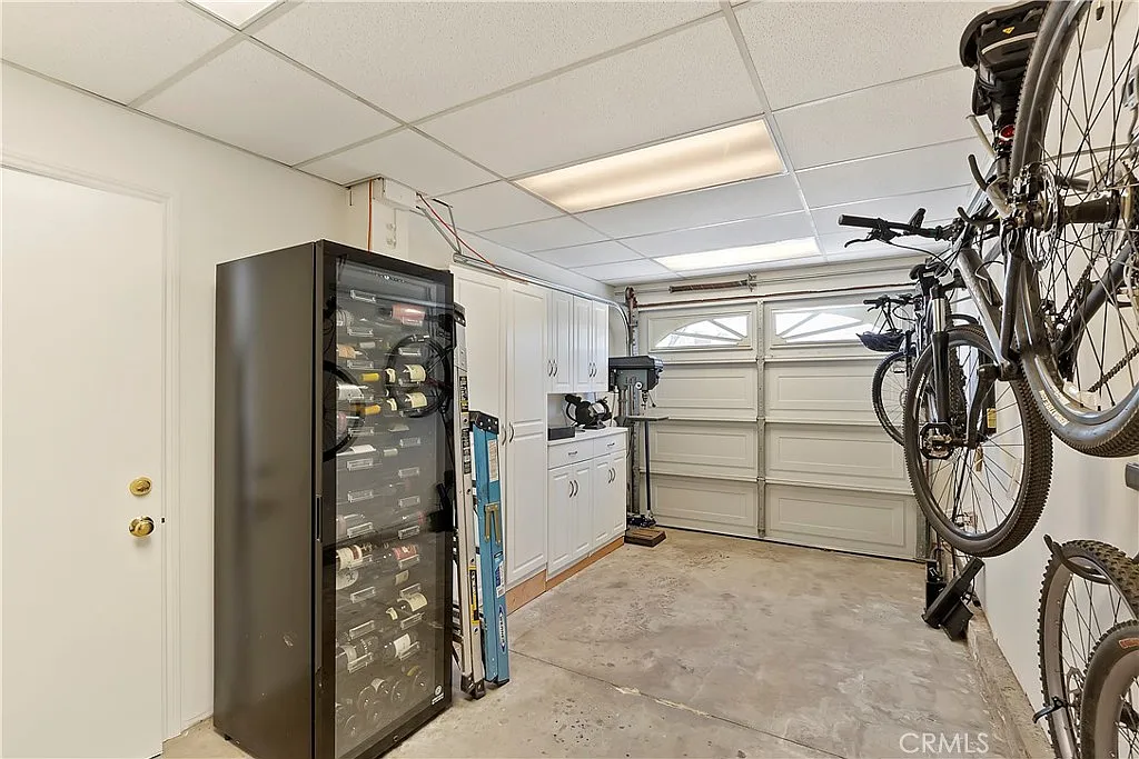 Garage with storage cabinet, washing machine, and two wall-mounted bicycles