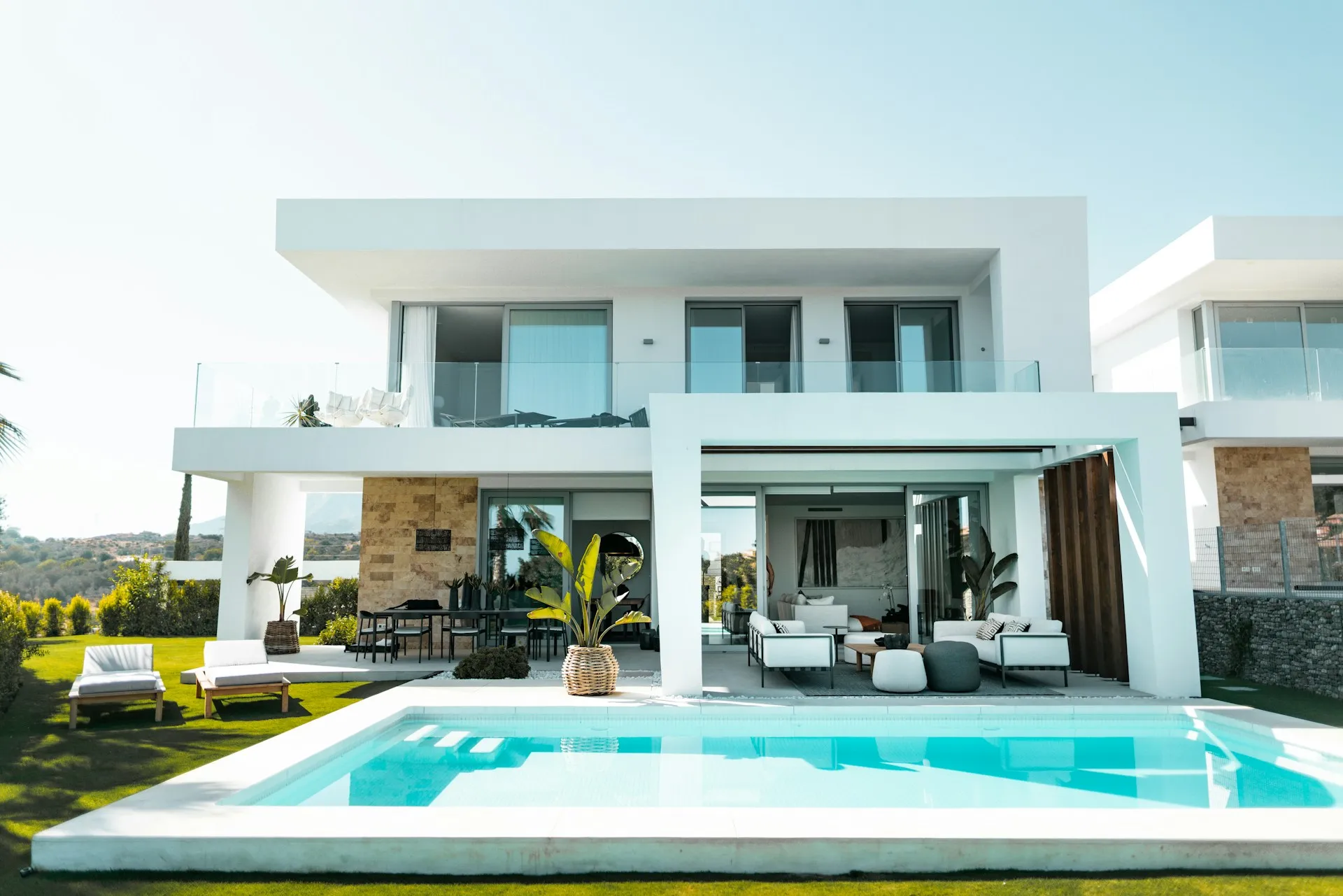Villa with swimming pool, spacious outdoor area, and large glass doors and windows.